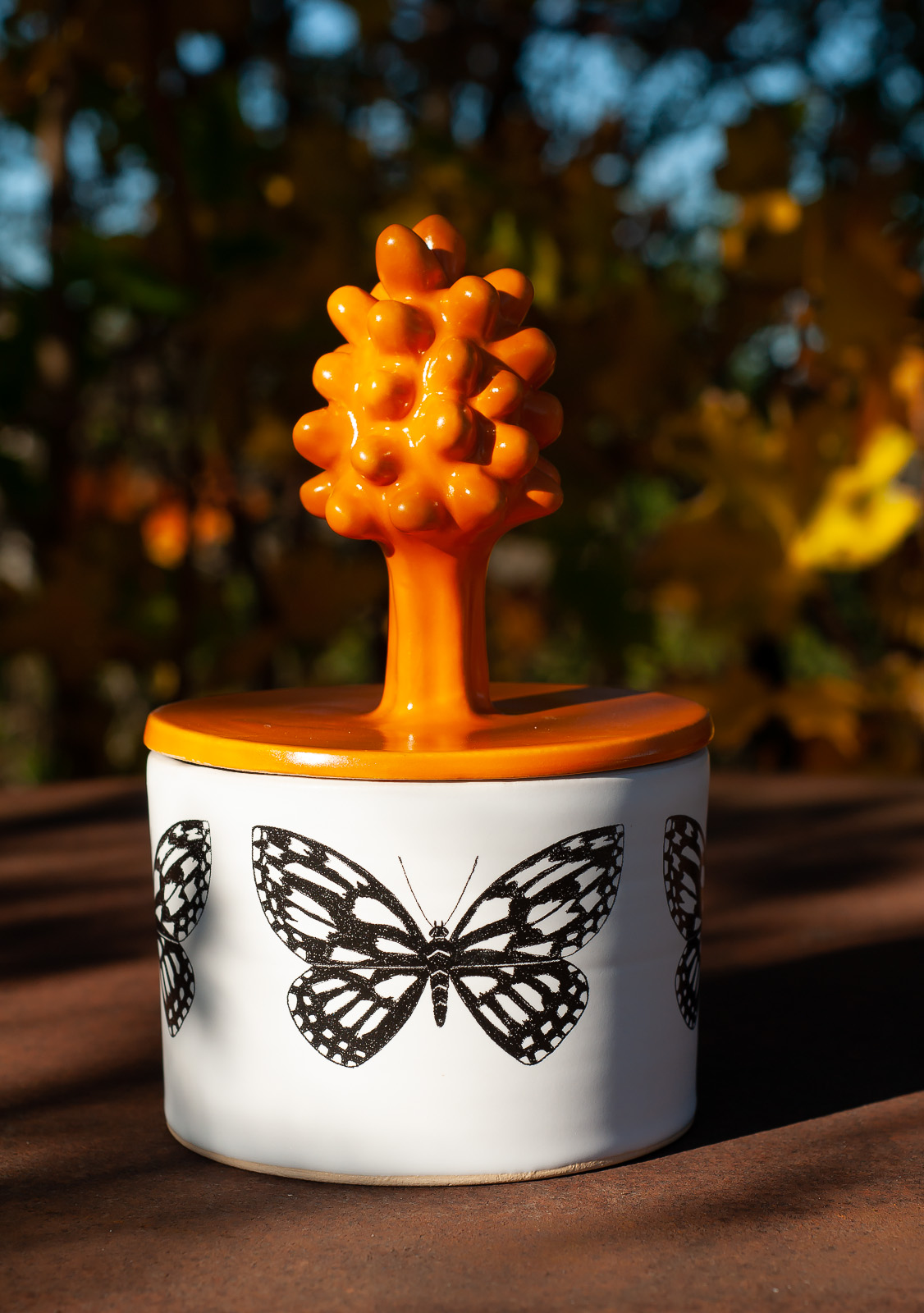 Burk med fjäril, orange lock med blomknopp.