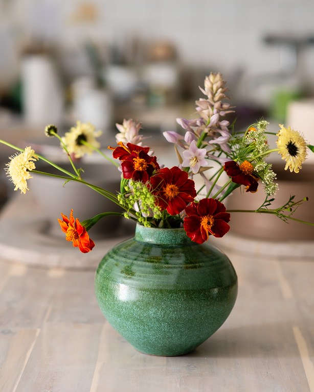 Vas med liten kant och sommarblommor i vasen, keramik av Elna-Karin Helgesson